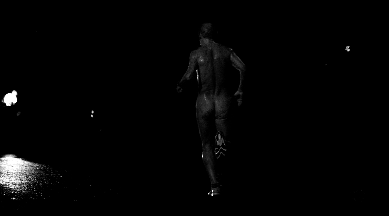 Un hombre corre desnudo en la noche con sus deportivas.
